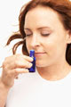 woman smellign aromatherapy oil