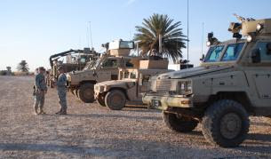 A row of armored vehicles — RG-31s, a Humvee and a Buffalo — are ready to leave on patrol.