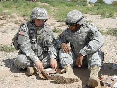 Two Soldiers look at the components of the First Strike Ration during a recent evaluation at Fort Bliss, Texas.