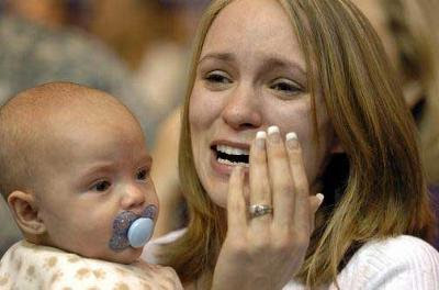 Laura Busby, holding her 5-month-old son, Zachary, sheds tears of joy as she sees her husband, Sgt. Alan Busby, who returned home safely from Iraq Nov. 11, 2007.