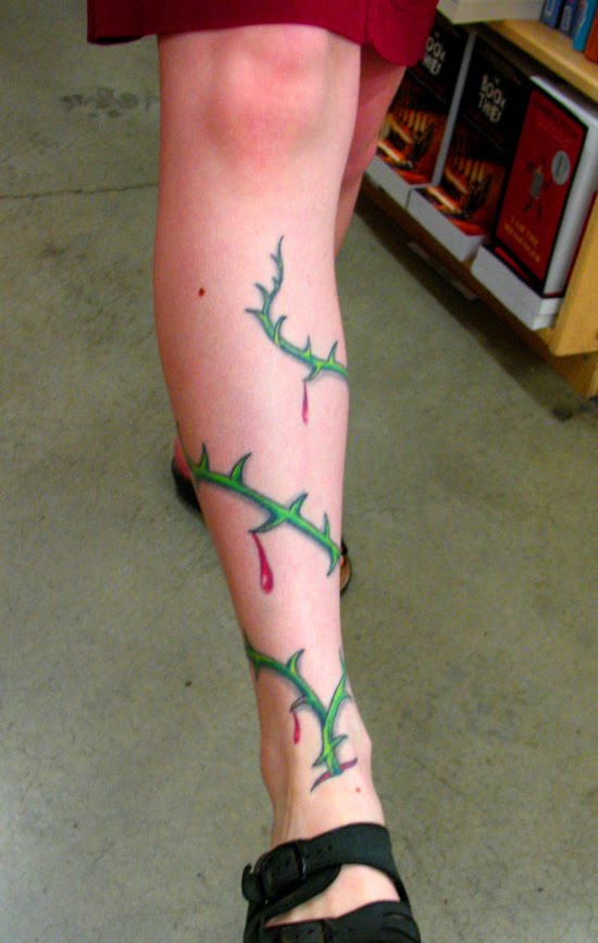ink tattoo of a thorny vine which wrapped around a young female's leg