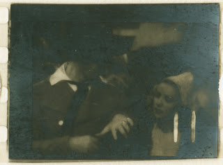 A dimly lit photograph of a man and woman close together.