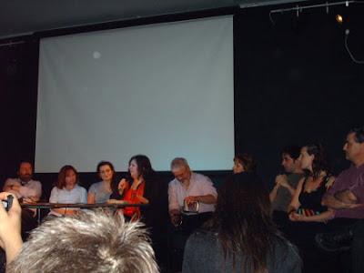 Todos los escritores de la antología, sentados de frente al público.