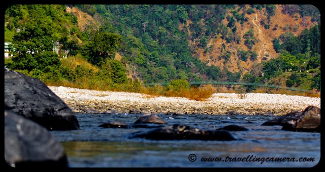 Ramganga River near National Jim Corbett Park: Posed by VJ @ www.travellingcamera.com: Two years back we choose Jim Corbett for year end trip and stayed at Ram Ganga Resort at the banks of Ramganga River. Here are few photographs of Ramganga River in Uttrakhand.Ramganga West river originates from Doodhatoli ranges in the district of Pauri Garhwal, Uttarakhand state of India. The river Ramganga flows to south west from Kumaun Himalaya. It is a tributary of the river Ganga, originates from the high altitude zone of 800m-900m. Ramganga flows by the Corbett National Park near Ramnagar of Nainital district from where it descends upon the plains. Bareilly city of Uttar Pradesh is situated on its banks. There is a dam across this river at Kalagarh for irrigation and hydroelectric generation.boulders strewn across the rive bed. These can be seen in almost any river as it reaches the plains.Ink blue... The river is mostly shallow with deep areas here and there. It can be treacherous.Some of these mountain rivers have slogged over thousands of centuries to carve their ways through the mountains. Erosion is an example of slow and steady wins the race...All around the ram ganga resort, the landscape is hilly with some excellent trekking trails. This photo was shot from one of them.Ram Ganga Resort at the banks of the Ram Ganga River.