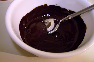 Spoon stirring melted chocolate in bowl