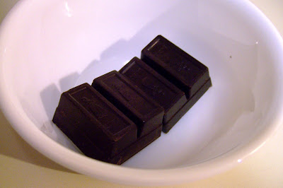 Two square of bakers chocolate in white bowl