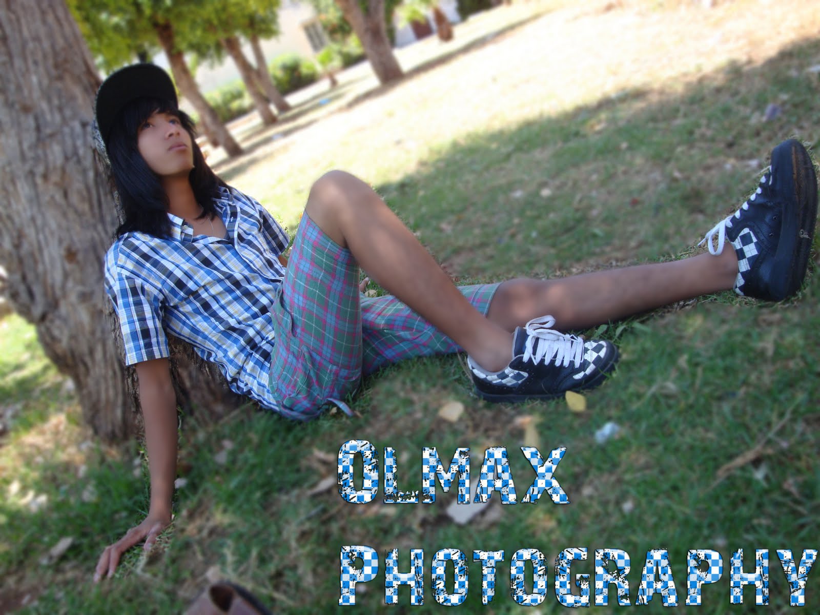 A scene kid with bright pink, teased hair styled into a high volume cut, wearing a colorful graphic tee and chunky accessories.