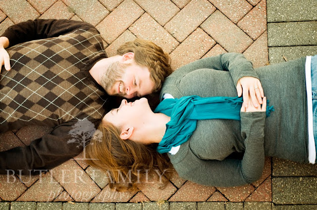 Bird's eye view portrait of the couple laying on brickwork and looking at eachother