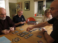 Players deep in concentration during a game of Dominion
