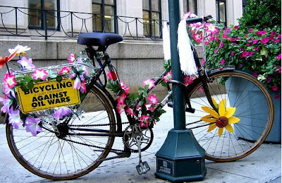 Image of bikes with flowers and Bicycling Against Oil Wars sign