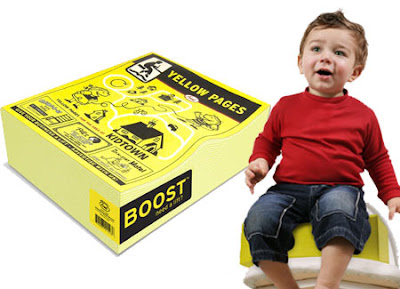 Product photo of a child's booster seat that looks like a big fat yellowpages book