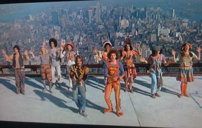 Cast dancing on a rooftop with Manhattan in the background
