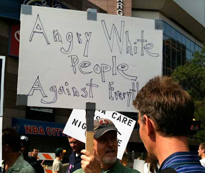 Man with sign reading Angry White People Against Everything