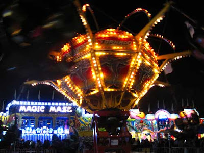 Colored lights of a ride, Magic Maze sign lit in the background