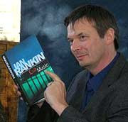 Photo of novelist Ian Rankin with a copy of his book Exit Music