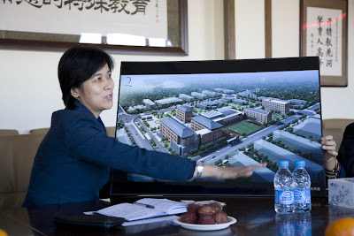 Woman pointing to a large picture of proposed buildings