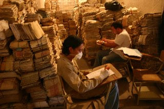 piles of documents, workers in masks