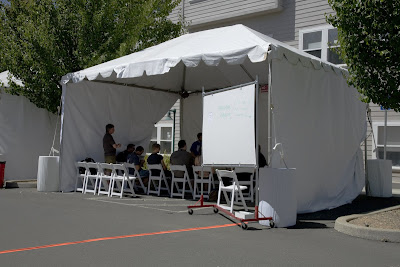Tent with chairs and people in a meeting session