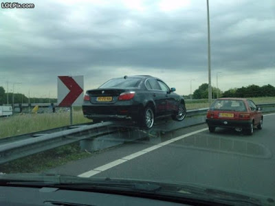 photo of a car parked on a guardrail