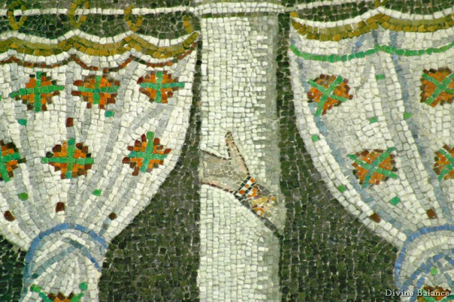 Mosaic of hand symbol on pillar, with curtains on both sides.