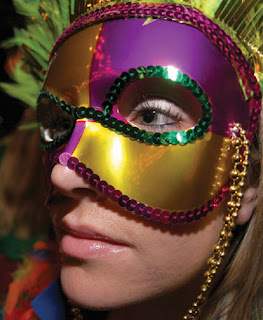 A beautiful and sexy girl wearing Gold color Mardi gras festival mask with mardi gras breeds looks cute on her face gallery
