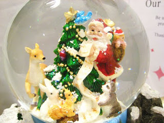 Santa Claus with gifts and rabbits at Christmas Tree in the Transparent Christmas snow globe