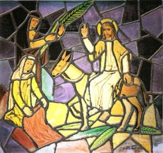 Stained glass art of Jesus on donkey and women praying to him during his entrance into Jerusalem on PalmSunday day