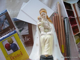 Statuette of Mary next to art supplies