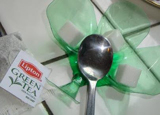 Spoon and sugar cubes on bowl with Lipton green tea packet
