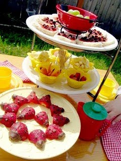 Tea tray tower with fruits on it including strawberries made to look like ladybugs