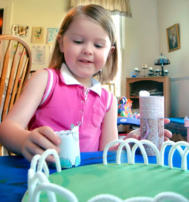 Girl playing with shepherd and sheep standees in craft pasture