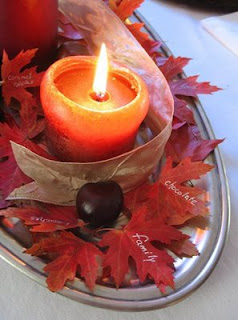 Thanksgiving centerpiece with fruits, candles, and leaves that have been written on