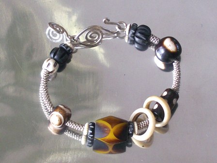African wood and bone beads anchored on sterling silver with a hammered silver clasp - $54