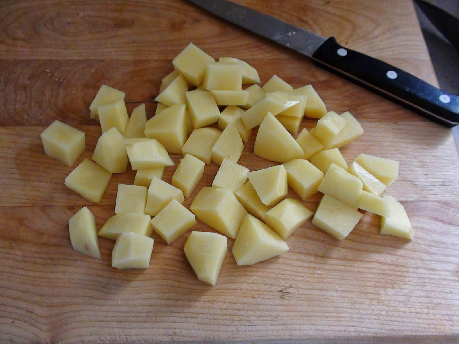 Рубленный картофель. Рубленная картошка. Картошка нарезанная на маленькие кубики на зеленой доске. Сухой рубленный картофель. Как порезать картошку средними кубиками.