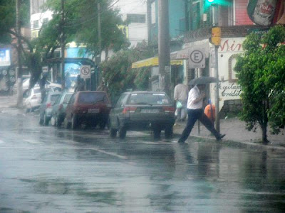 pedestre pulando uma poça d'água na chuva em porto alegre