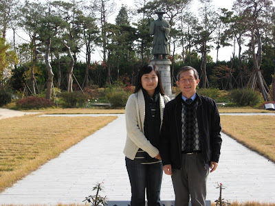 Miss Cho and Mr Lee in front of statue of first Korean Catholic Saint