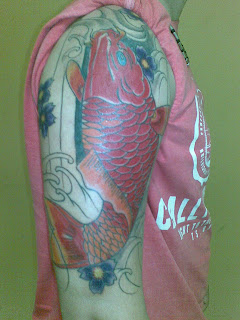 tatuagem de carpa vermelha subindo no braço