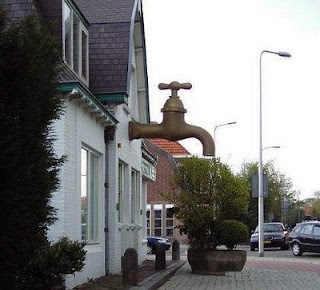 funny house photo with a really large water tap out the front