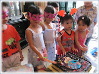 Twins cutting their birthday cake, with cousins joining in the fun