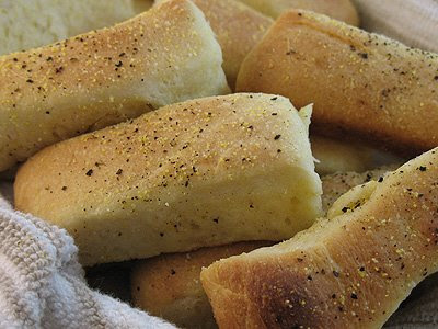 A close up photo of pull apart cornmeal dinner rolls in a napkin.