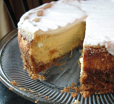 A close up photo of a mandarin orange cheesecake with a slice removed.