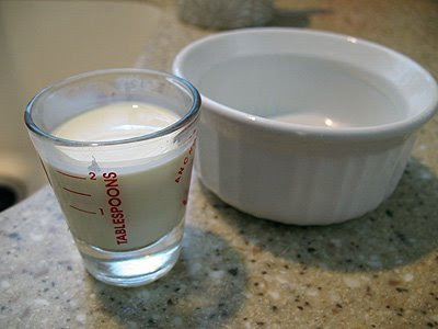 A small cup of whipping cream and an empty ramekin in the background.