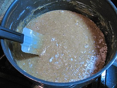 A close up photo of the dry ingredients being mixed into the butter mixture in a saucepan.