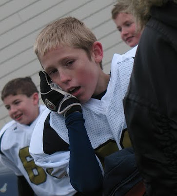An old photo of Amanda\'s son TJ on the sidelines in his football uniform.