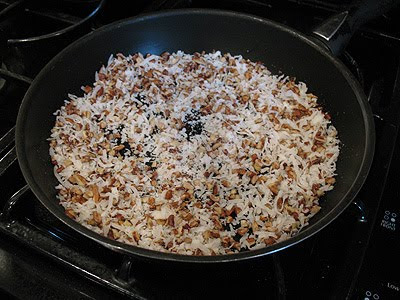 A photo of a skillet of coconut and pecans.