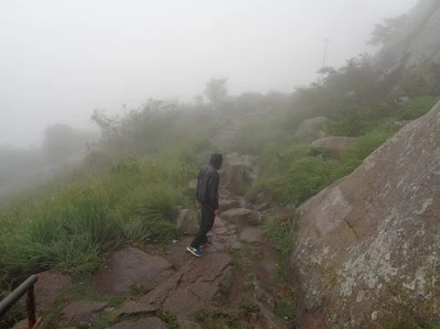 hiker cautiously treks down into the flat land at shivagange