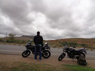 Madhu enjoying the ride back, with windmills visible on the highway back to Bangalore