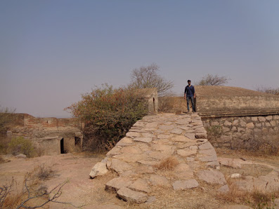 Hiker walking up the fort wall on the summit of Bhasmangi