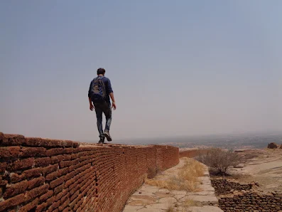 Deefu walking on the top most fort wall on the summit at bhasmangi