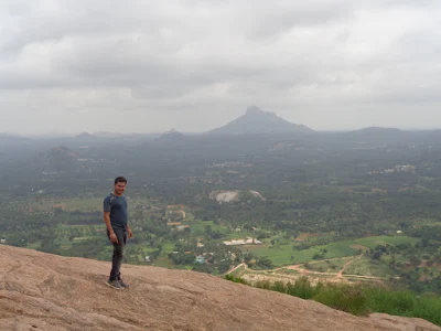 Avi at the summit of Bhairavadurga with Shivagange seen afar in the background
